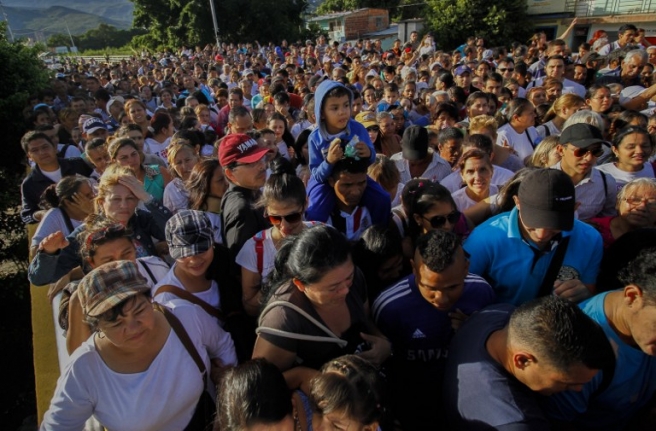 Venezuelans cross from San Antonio del Tachira, Venezuela to Cucuta, Colombia on July 10, 2016. Thousands of Venezuelans crossed Sunday the border with Colombia to take advantage of its 12-hour opening after it was closed by the Venezuelan government 11 months ago. Venezuelans rushed to Cucuta to buy food and medicines which are scarce in their country. / AFP PHOTO / Schneyder Mendoza