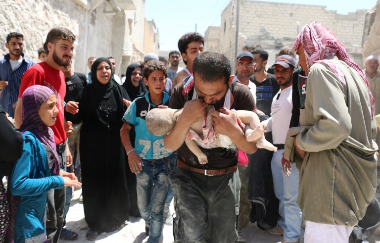 A Syrian man holds the body of his child after it was taken from under the rubble of destroyed buildings following a reported air strike on the rebel-held neighbourhood of al-Marjah in the northern city of Aleppo, on July 24, 2016. Air raids have hit four makeshift hospitals in Syria's battered Aleppo city, doctors said, jeopardising medical care for more than 200,000 desperate civilians in rebel-held areas. The bombardment since July 23 has worsened the plight of residents of besieged eastern neighbourhoods of Syria's second city, where food and medical supplies are becoming increasingly scarce. / AFP PHOTO / AMEER ALHALBI