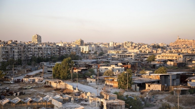 A picture taken on July 29, 2016 shows a general view of Karaj al-Hajz corridor (C) in the rebel-held part of Aleppo, leading towards the government controlled area of the Masharqa neighbourhood (background). Only a few residents of Syria's Aleppo were able to leave encircled opposition-held districts through humanitarian corridors before rebels prevented them from fleeing, the Syrian Observatory for Human Rights said on July 28, adding that Russia, a key ally of President Bashar al-Assad, on July 27 announced the opening of aid passages for civilians and surrendering fighters seeking to exit the city's rebel-held eastern neighbourhoods but regime aircraft bombed eastern areas of Aleppo overnight. / AFP PHOTO / KARAM AL-MASRI