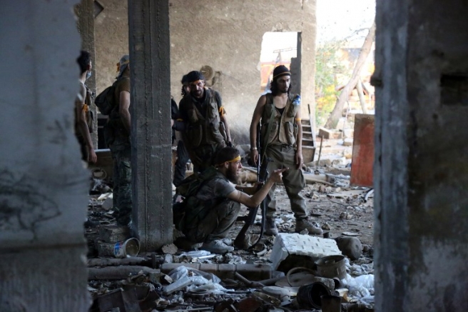 Rebel fighters speak during clashes with regime forces in Ramussa on the southwestern edges of Syria's northern city of Aleppo on August 6, 2016. Syrian rebels said they have broken a three-week government siege of second city Aleppo, turning the tables on Russian-backed regime forces who are now on the defensive. / AFP PHOTO / FADI AL-HALABI