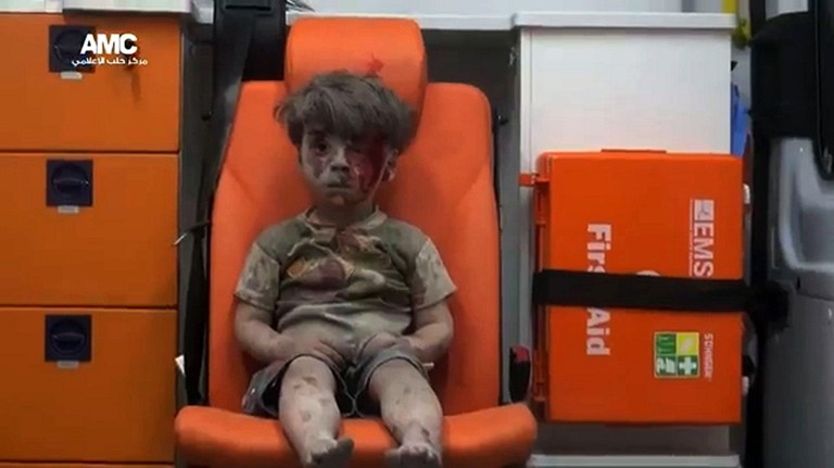 An image grab taken from a video uploaded by the Syrian opposition's activist group Aleppo Media Centre (AMC) on August 17, 2016 is said to show Omran, a four-year-old Syrian boy covered in dust and blood, in an ambulance after being rescued from the rubble of a building hit by an air strike in the rebel-held Qaterji neighbourhood of the northern Syrian city of Aleppo. / AFP PHOTO / AMC / HO / === RESTRICTED TO EDITORIAL USE - MANDATORY CREDIT "AFP PHOTO / HO / AMC " - NO MARKETING NO ADVERTISING CAMPAIGNS - DISTRIBUTED AS A SERVICE TO CLIENTS FROM ALTERNATIVE SOURCES, AFP IS NOT RESPONSIBLE FOR ANY DIGITAL ALTERATIONS TO THE PICTURE'S EDITORIAL CONTENT, DATE AND LOCATION WHICH CANNOT BE INDEPENDENTLY VERIFIED === /