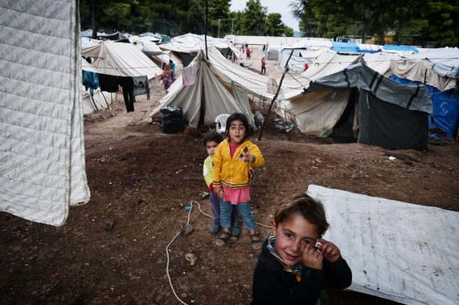 Children play inside the Ritsona refugee camp, north of Athens on October 21, 2016. The camp hosts some 500 refugees, mostly Syrian and Syrian-Kurd families living in tents and waiting to move to container houses. More than 60.000 refuges are stranded in Greece since the closure of the borders. / AFP PHOTO / LOUISA GOULIAMAKI