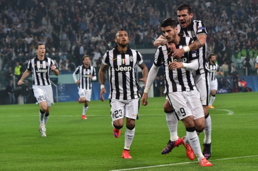 Juventus' forward from Spain Alvaro Morata celebrates with teammates after scoring during the UEFA Champions League semi-final first leg football match Juventus vs Real Madrid on May 5, 2015 at the Juventus stadium in Turin.      AFP PHOTO / GIUSEPPE CACACE