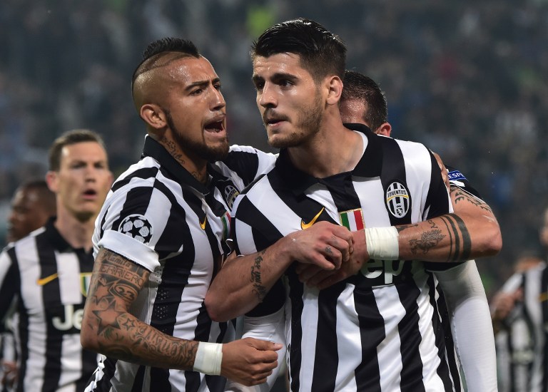Juventus' forward from Spain Alvaro Morata (C) celebrates with teammates Juventus' midfielder from Chile Arturo Vidal (L) and Juventus' midfielder Stefano Sturaro after scoring during the UEFA Champions League semi-final first leg football match Juventus vs Real Madrid on May 5, 2015 at the Juventus stadium in Turin.      AFP PHOTO / GIUSEPPE CACACE