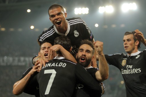 Real Madrid's Portuguese forward Cristiano Ronaldo celebrates with teammates after scoring during the UEFA Champions League semi-final first leg football match Juventus vs Real Madrid on May 5, 2015 at the Juventus stadium in Turin.       AFP PHOTO / MARCO BERTORELLO