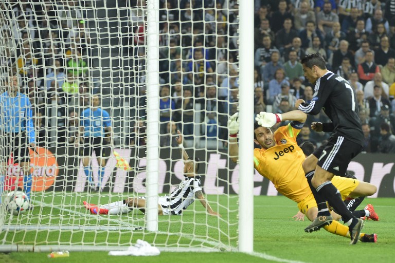 Real Madrid's Portuguese forward Cristiano Ronaldo (R) scores against Juventus' goalkeeper and captain Gianluigi Buffon during the UEFA Champions League semi-final first leg football match Juventus vs Real Madrid on May 5, 2015 at the Juventus stadium in Turin.        AFP PHOTO / OLIVIER MORIN