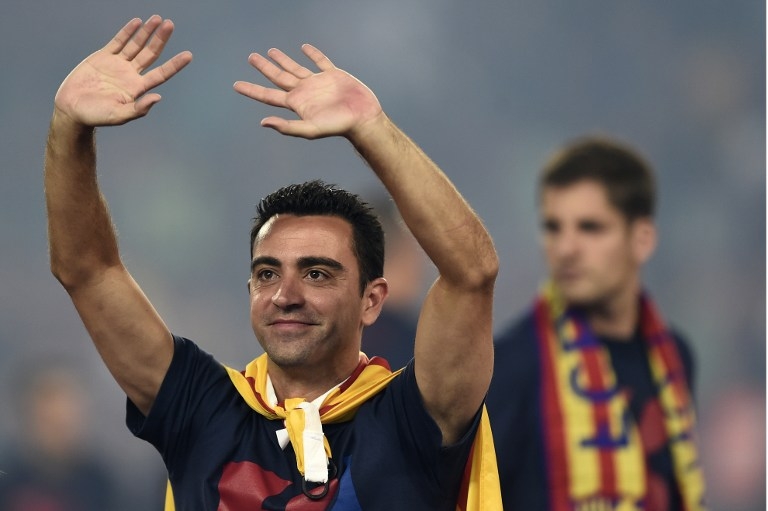 Barcelona's midfielder Xavi Hernandez waves as he takes part in the celebrations held for their victory over Juventus, one day after the UEFA Champions League final football, at the Camp Nou stadium in Barcelona on June 7, 2015. Luis Suarez and Neymar scored second-half goals to give Barcelona a 3-1 Champions League final victory over Juventus on June 6, 2015 as the Spaniards became the first team to twice win the European treble. AFP PHOTO/ JOSEP LAGO