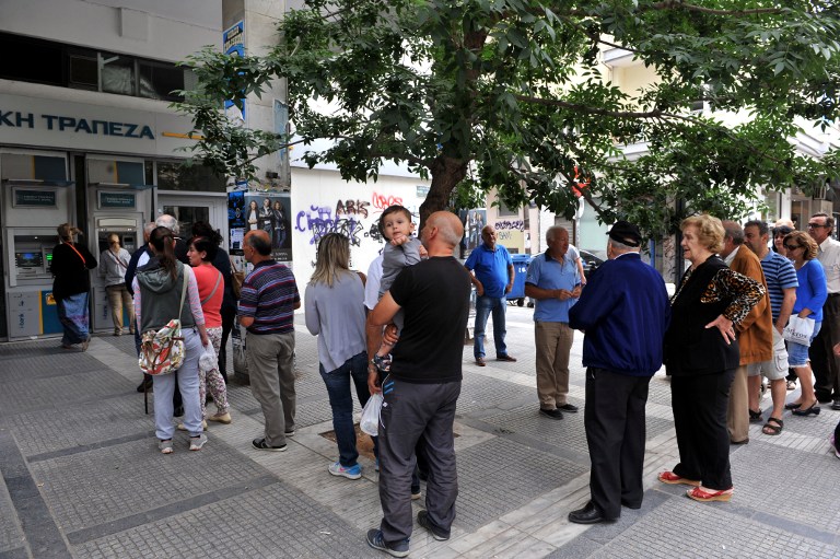People stand in a queue to use ATM machines at a bank in Thessaloniki on June 27, 2015.  Greece will hold a referendum on July 5 on the outcome of negotiations with its international creditors taking place in Brussels on June 27, Prime Minister Alexis Tsipras announced.  AFP PHOTO /Sakis Mitrolidis