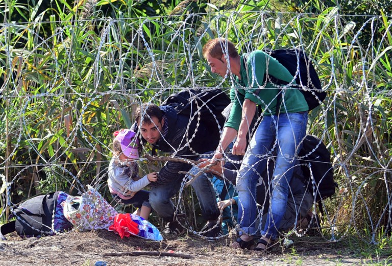 Izbjeglice prelaze žičanu ogradu koju je Mađarska podigla na granici sa Srbijom
