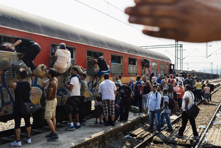 Željeznička stanica u južnoj Makedoniji prepuna je očajnih migranata koji se pokušavaju ukrcati u vlakove prema Europi, u nadi da će ondje započeti novi život. Oni koji se zbog pritiska tisuća ljudi koji su u jednako mučnoj situaciji ne stignu ukrcati regularnim putem, pokušavaju u vlak ući na sve načine, pa i kroz uske prozore. AFP PHOTO / DIMITAR DILKOFF