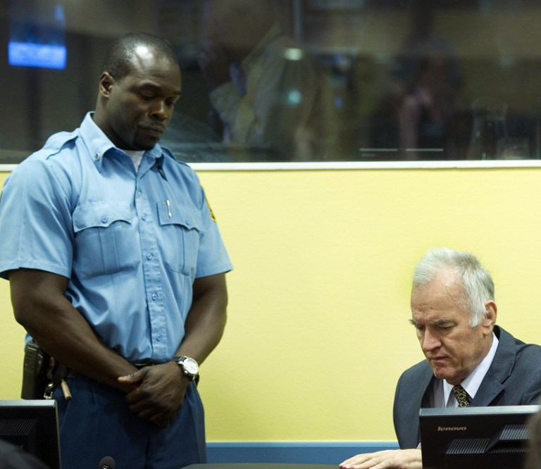 Former Bosnian Serb army chief Ratko Mladic (R) sits on May 16, 2012 at the International Criminal Tribunal for the former Yugoslavia (ICTY) in The Hague before the opening of his war crimes trial. Mladic faces 11 counts including genocide, war crimes, and crimes against humanity for his role in the Bosnian war, in particular the 1995 Srebrenica massacre. AFP PHOTO / POOL / TOUSSAINT KLUITERS - netherlands out -