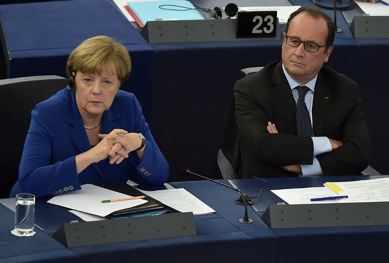 French President Francois Hollande (R) sits next to German Chancellor Angela Merkel (L) during their joint address at the European Parliament on October 7, 2015 in Strasbourg, eastern France. Angela Merkel and Francois Hollande are set to give a joint address, the first such event by leaders of the two countries since 1989. Merkel and Hollande, the leaders of the European Union's two biggest economies, have played a driving role in a series of challenges that have gripped the 28-nation bloc, ranging from the migrant crisis to the Greek debt saga and the conflict in Ukraine. Failure to act in Syria risks stoking a "total war" in the Middle East, Francois Hollande said in a landmark speech to the European Parliament alongside Angela Merkel. AFP PHOTO / PATRICK HERTZOG