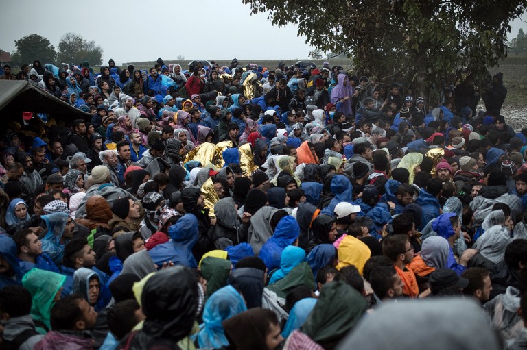 Migrants wait to enter Croatia from the Serbia-Croatia border, near the western Serbian village of Berkasovo, on October 19, 2015. Long lines have formed on Croatia's border with Serbia. Several hundred people remained stuck there on October 19 morning, after having spent the night in rain and cold weather. Earlier on OCtober 18, 2015, migrants were forced to sit for several hours in about 50 buses stuck in Serbia near the border after Croatia stopped allowing any crossings. They later resumed, but at a much slower pace than before. AFP PHOTO / ANDREJ ISAKOVIC