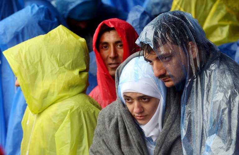 Migrants and refugees wait in the rain as they wait to enter Slovenia, at the Croatian-Slovenian border in Trnovec, on October 19, 2015. Slovenian authorities said today they had refused to let in more than 1,000 migrants arriving from Croatia after a daily quota had been reached, stoking fears of a new human bottleneck on the western Balkan route. AFP PHOTO /