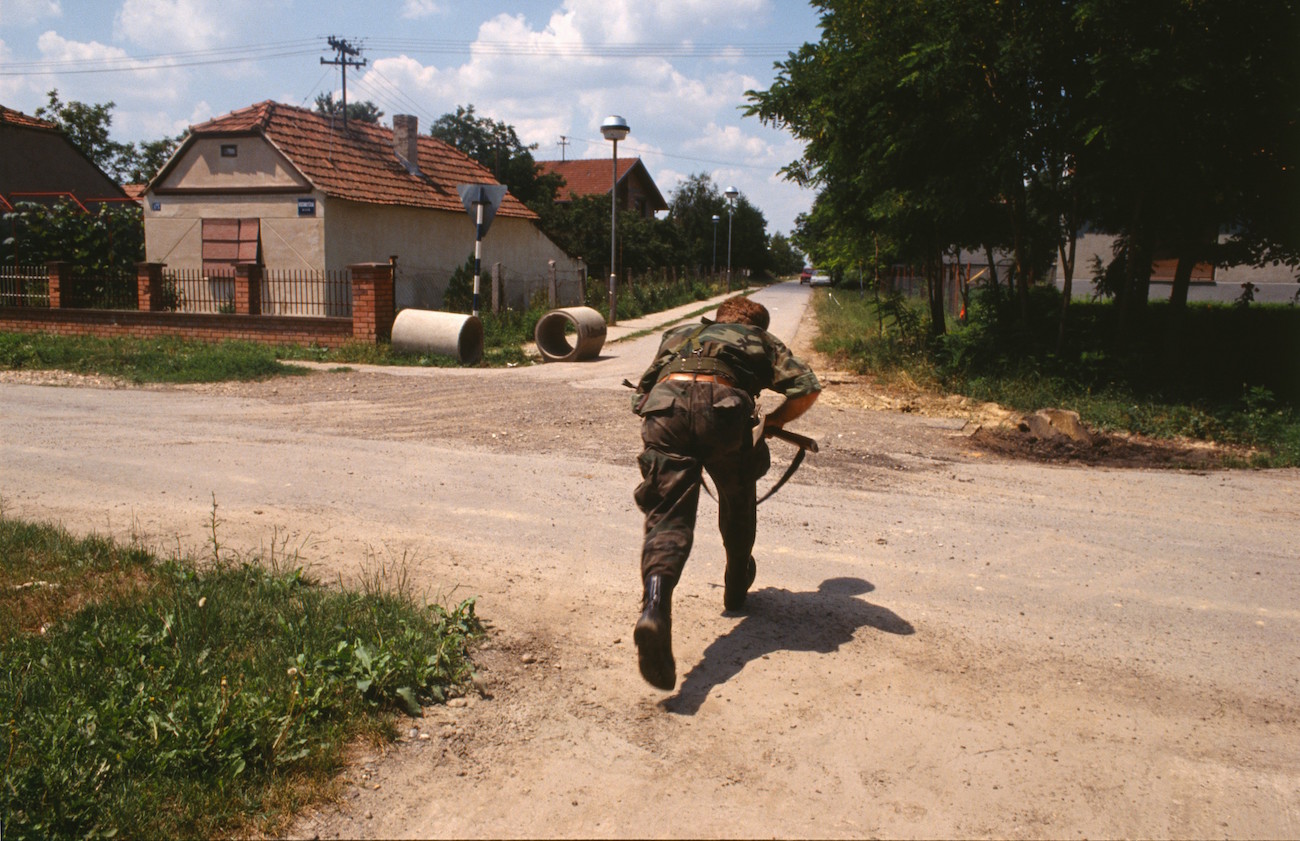 A Croatian soldier runs across the road in the suburbs of Vukovar., Image: 17623486, License: Rights-managed, Restrictions: Content available for editorial use, pre-approval required for all other uses. This content may not be materially modified or used in composite content., Model Release: no, Credit line: Profimedia, Corbis