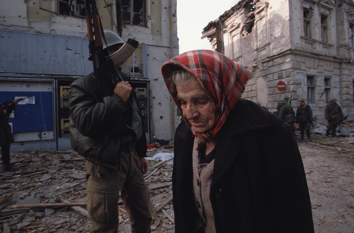 Ethnic Cleansing - A Croatian woman walks past a Serbian fighter as she leaves her destroyed city of Vukovar, Croatia, Nov. 24, 1991. Vukovar was under siege for three months by Serbian forces and completely destroyed., Image: 116177610, License: Rights-managed, Restrictions: Content available for editorial use, pre-approval required for all other uses. This content not available to be downloaded through Quick Pic Not available for license and invoicing to customers located in the Czech Republic. Not available for license and invoicing to customers located in the Netherlands. Not available for license and invoicing to customers located in India. Not available for license and invoicing to customers located in Italy. Not available for license and invoicing to customers located in Finland., Model Release: no, Credit line: Profimedia, Corbis VII
