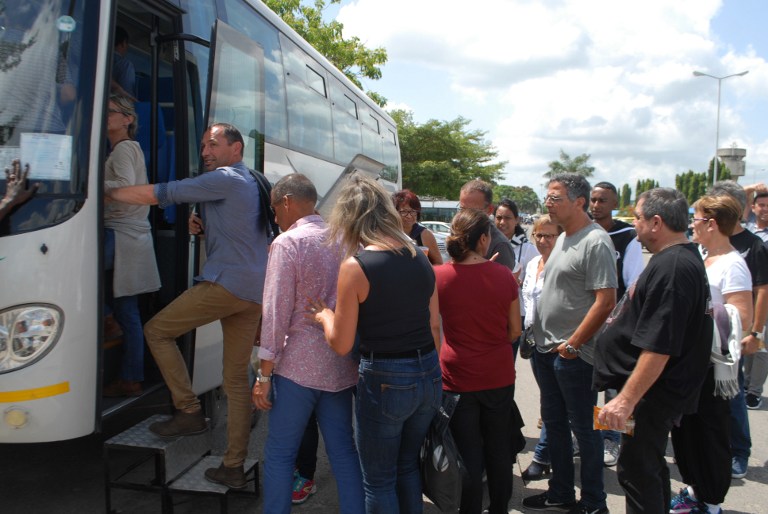 Passengers board a bus at Moi International Airport in Mombasa as their Air France flight from Mauritius to Paris is grounded after a suspected bomb was found on board on December 20, 2015. An Air France flight from Mauritius to Paris was forced to make an emergency landing in Kenya early today after a suspected bomb was found on board, police said. Navy and police bomb experts were called in to determine if there were any explosives on board the plane, which had 459 passengers and 14 crew members aboard. / AFP / -