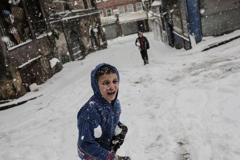 Children play with snowballs during a snowfall in Istanbul on December 31, 2015. Istanbul governors office has urged people to avoid going outside unless necessary, citing expectation of heavy snowfall until January 2, 2016. / AFP / YASIN AKGUL