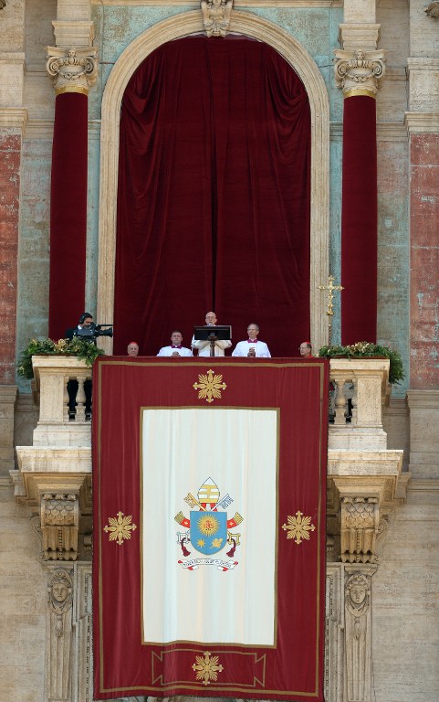 Pope Francis stands at the balcony of St Peter's basilica during the traditional "Urbi et Orbi" Christmas message to the city and the world, on December 25, 2015 at St Peter's square in Vatican. Pope Francis was expected to appeal for reconciliation of fractured communities in his Christmas Day blessing Friday, as the world takes stock of a year of violence and suffering that saw hundreds of thousands flee their homes. AFP PHOTO / VINCENZO PINTO / AFP / VINCENZO PINTO