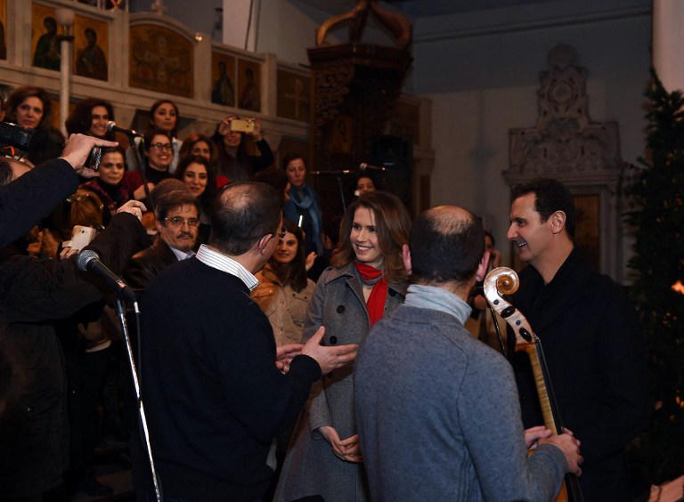 A handout image obtained from the official facebook page of the Syrian Presidency shows Syrian President Bashar al-Assad (R) and his wife Asma al-Assad (3rd-R) attending a Christmas choral presentation at the Lady of Damascus Catholic Church in the Syrian capital on December 18, 2015. AFP PHOTO / HO / THE OFFICIAL FACEBOOK PAGE OF THE SYRIAN PRESIDENCY == RESTRICTED TO EDITORIAL USE - MANDATORY CREDIT "AFP PHOTO / HO / THE OFFICIAL FACEBOOK PAGE OF THE SYRIAN PRESIDENCY" - NO MARKETING NO ADVERTISING CAMPAIGNS - DISTRIBUTED AS A SERVICE TO CLIENTS == / AFP / SYRIAN PRESIDENCY FACEBOOK PAGE / HO