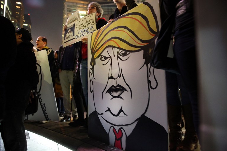NEW YORK, NY - DECEMBER 10: A protester holds a caricature of conservative presidential candidate Donald Trump during a demonstration against racism and Trump's recent remarks concerning Muslims on December 10, 2015 in New York City. Dozens or demonstrators and activists converged at Columbus Circle to denounce the politics of Trump and the treatment of Muslim refugees both in America and Europe. Spencer Platt/Getty Images/AFP