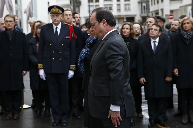 French President Francois Hollande pays his respects after unveiling a commemorative plaque outside the former offices of French weekly satirical newspaper Charlie Hebdo on January 5, 2016 in Paris, during a ceremomy to pay tribute to the victims of the last year's January attacks in Paris. A total of 17 people were killed in the three days of attacks dubbed "France's 9/11", marking the start of a string of jihadist strikes in the country that culminated in November's massacre in Paris. / AFP / POOL / BENOIT TESSIER