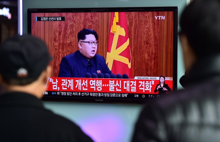 Commuters walk past a television screen showing a broadcast of North Korean leader Kim Jong-Un's New Year speech, at a railroad station in Seoul on January 1, 2016. North Korean leader Kim Jong-Un said raising living standards was his number one priority in an annual New Year's address on January 1 that avoided any explicit reference to the country's nuclear weapons programme. AFP PHOTO / JUNG YEON-JE / AFP / JUNG YEON-JE
