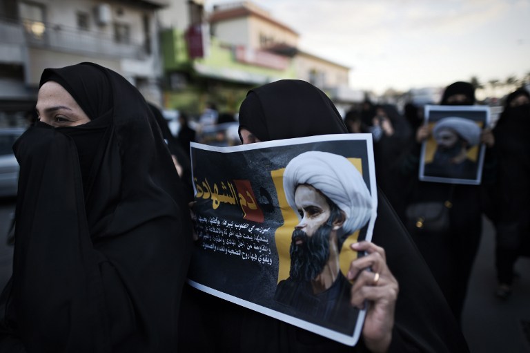 Bahraini women hold posters bearing portraits of prominent Shiite Muslim cleric Nimr al-Nimr during a protest against his execution by Saudi authorities, in the village of Jidhafs, west of the capital Manama on January 3, 2016. Iraq's top Shiite leaders condemned Saudi Arabia's execution of Nimr, warning ahead of protests that the killing was an injustice that could have serious consequences. AFP PHOTO / MOHAMMED AL-SHAIKH / AFP / MOHAMMED AL-SHAIKH