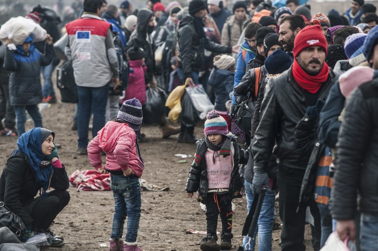 Migrants and refugees wait for security check after crossing the Macedonian border into Serbia, near the village of Miratovac, on January 29, 2016. More than one million migrants and refugees crossed the Mediterranean Sea to Europe in 2015, nearly half of them Syrians, according to the UN refugee agency, UNHCR. The International Organisation for Migration said las week that 31,000 had arrived in Greece already this year. / AFP / ARMEND NIMANI