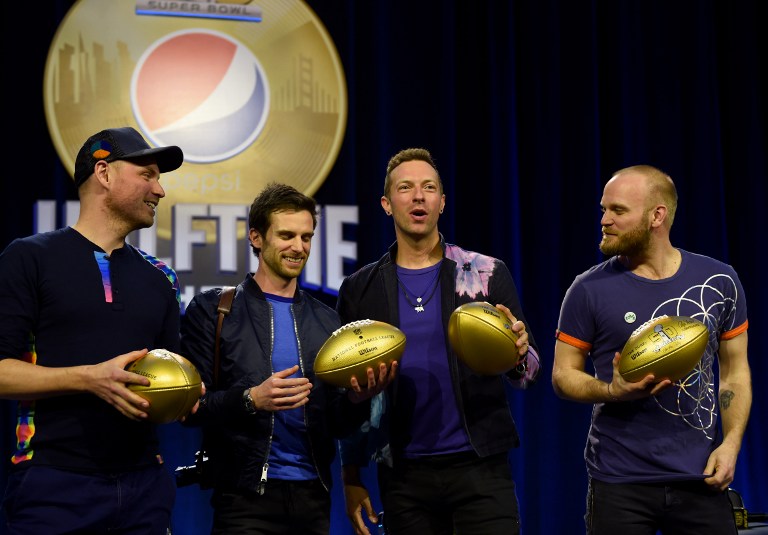 Musicians Jonny Buckland, Guy Berryman, Chris Martin and Will Champion Coldplay pose with footballs at the Pepsi Super Bowl Halftime Press Conference on February 4, 2016 at the Moscone Convention Center in San Francisco, California. / AFP / Timothy A. CLARY