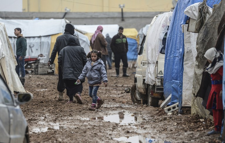 Syrian refugees are pictured in a camp as Syrians fleeing the northern embattled city of Aleppo wait on February 6, 2016 in Bab al-Salama, near the city of Azaz, northern Syria, near the Turkish border crossing. Thousands of Syrians were braving cold and rain at the Turkish border Saturday after fleeing a Russian-backed regime offensive on Aleppo that threatens a fresh humanitarian disaster in the country's second city. Around 40,000 civilians have fled their homes over the regime offensive, according to the Syrian Observatory for Human Rights monitor. / AFP / BULENT KILIC