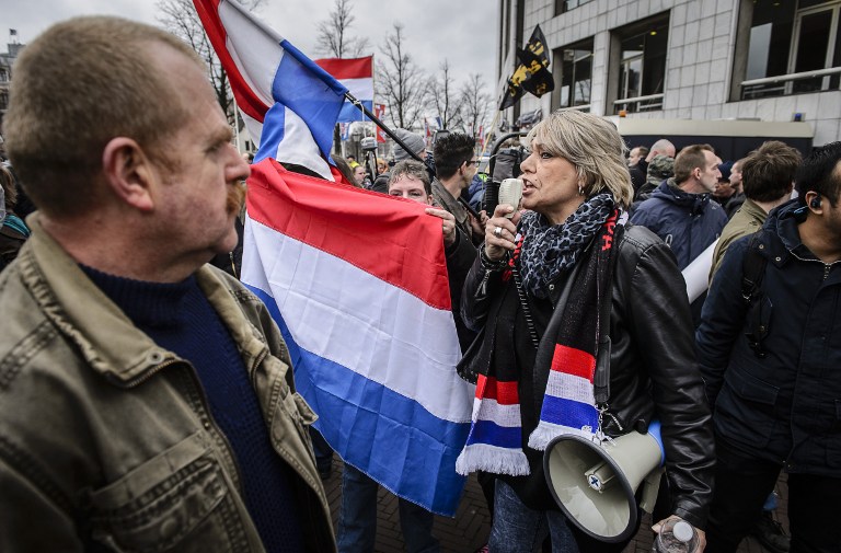 People wave national flags of the Netherlands as members of Pegida (Patriotic Europeans Against the Islamisation of the Occident) protest in central Amsterdam on February 6, 2016. Anti-Islamic group Pegida, which began as a movement in Germany in mid-2014 and has since spread to France and other European countries, has called on members and sympathisers across Europe to join marches on February 6. / AFP / ANP / Remko de Waal / Netherlands OUT
