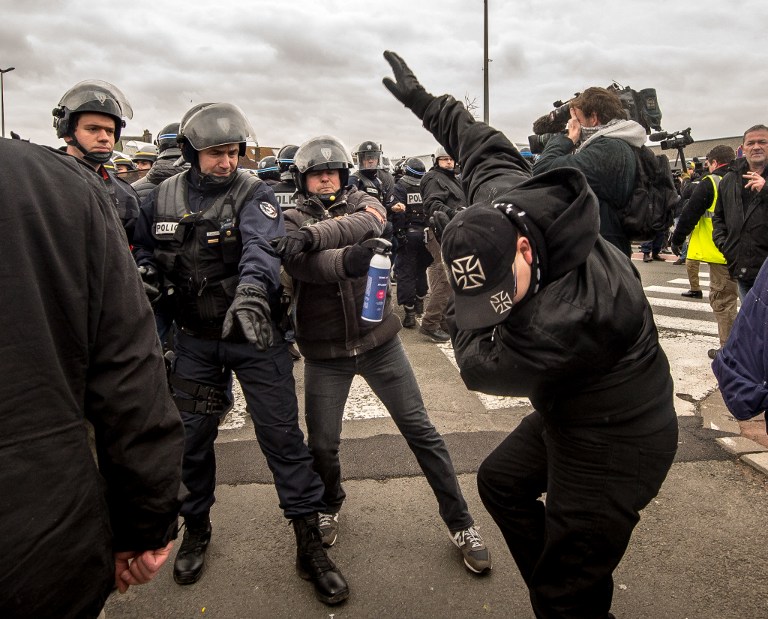 Policemen arrest a supporter of the Pegida movement (Patriotic Europeans Against the Islamisation of the Occident) during a demonstration in Calais, northern France on February 6, 2016. Anti-migrant protesters in the French port city of Calais clashed with police as they defied a ban and rallied in support of a Europe-wide initiative by the Islamophobic Pegida movement. / AFP / PHILIPPE HUGUEN