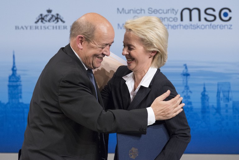 France's Defense Minister Jean-Yves Le Drian (L) embraces his German counterpart Ursula von der Leyen after they participated in a panel discussion at the 52nd Munich Security Conference (MSC) in Munich, southern Germany, on February 12, 2016. / AFP / THOMAS KIENZLE