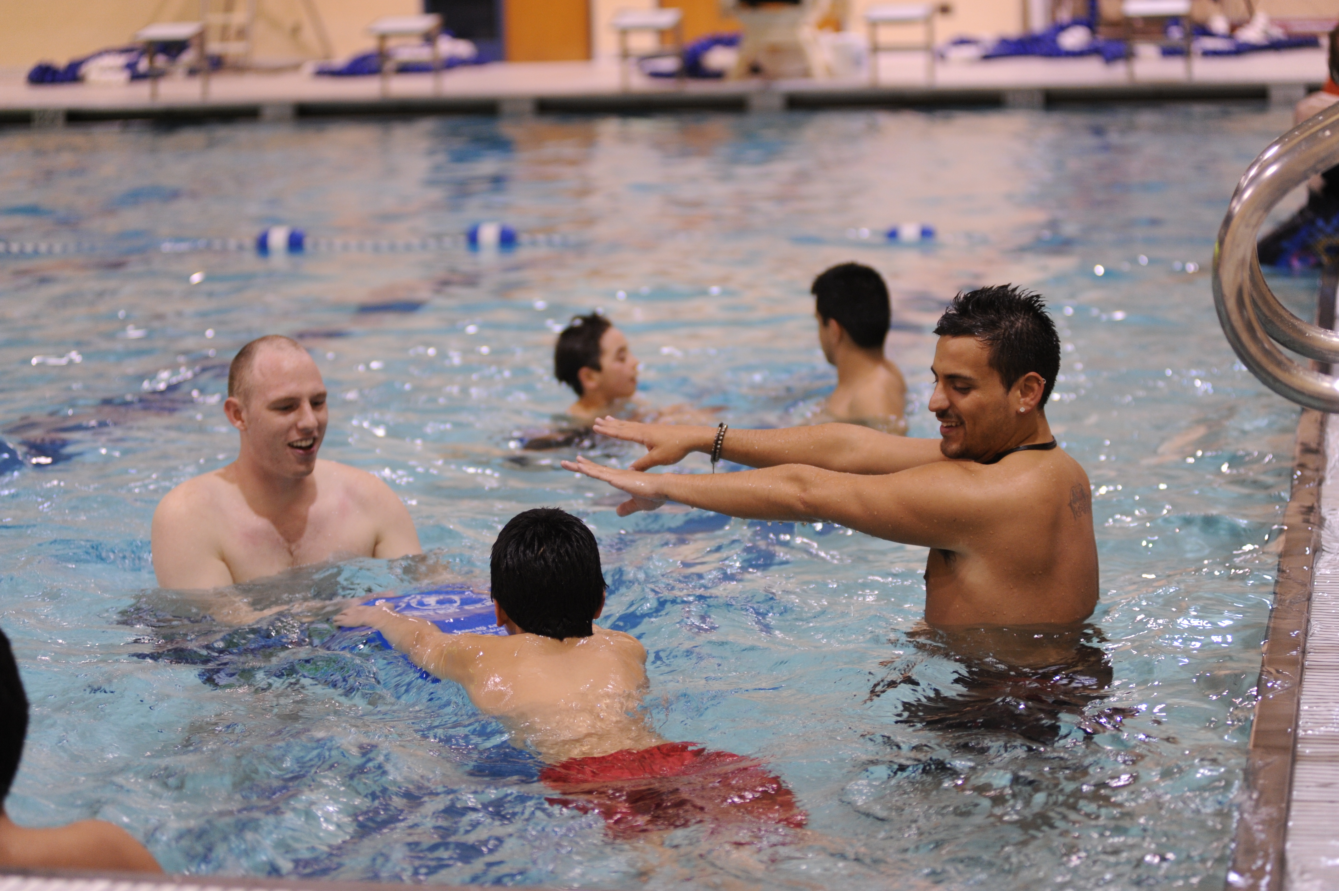 Kellus Sanchez, '11, helps a child to swim at the Berea Buddies swim party at Seabury Center pool on March 8, 2011.