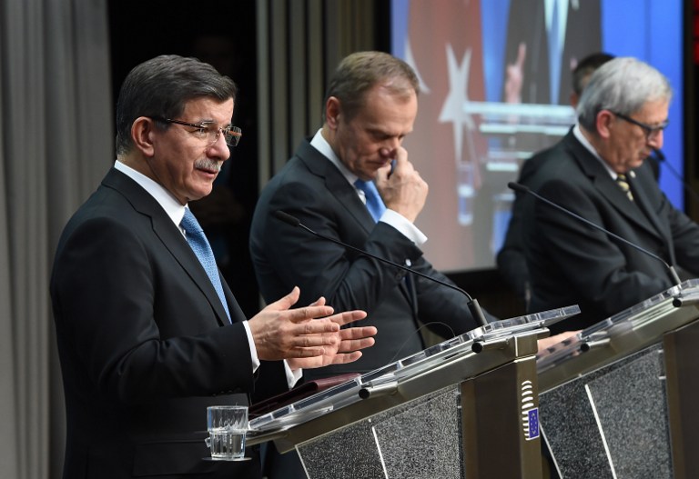 Turkey's Prime Minister Ahmet Davutoglu (L), European Council President Donald Tusk (C) and European Commission President Jean-Claude Juncker speak during a press conference at the end of an EU leaders summit with Turkey centered on the the migrants crisis, at the European Council, in Brussels on March 8, 2016. European Union leaders will on March 7 back closing down the Balkans route used by most migrants to reach Europe, diplomats said, after at least 25 more people drowned trying to cross the Aegean Sea en route to Greece. The declaration drafted by EU ambassadors on March 6 will be announced at a summit in Brussels on March 7, set to also be attended by Turkish Prime Minister Ahmet Davutoglu. / AFP / EMMANUEL DUNAND