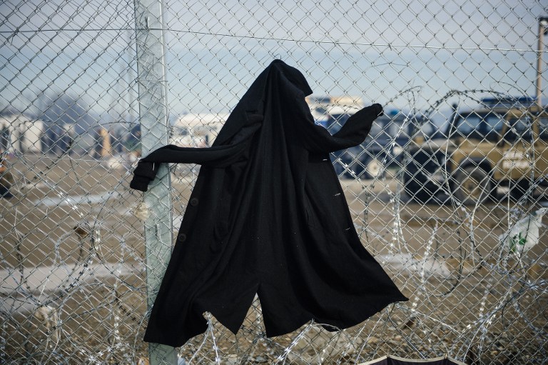 A picture taken on March 8, 2016 shows a coat hanging on the razor-topped fence dividing the Greek-Macedonian border near the Greek village of Idomeni where thousands of refugees and migrants are stranded. European Union leaders on March 7 hailed a "breakthrough" in talks with Turkey on a deal to curb the migrant crisis but delayed a decision until a summit next week to flesh out the details of Ankara's new demands. More than one million refugees and migrants have arrived in Europe since the start of 2015 -- the majority fleeing the war in Syria -- with nearly 4,000 dying while crossing the Mediterranean. / AFP / DIMITAR DILKOFF