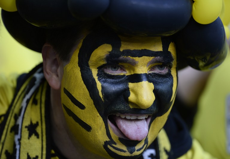 A Borussia Dortmund fan with a painted face cheers ahead of the start of the UEFA Champions League final football match between Borussia Dortmund and Bayern Munich at Wembley Stadium in London on May 25, 2013 AFP PHOTO / ADRIAN DENNIS / AFP / ADRIAN DENNIS