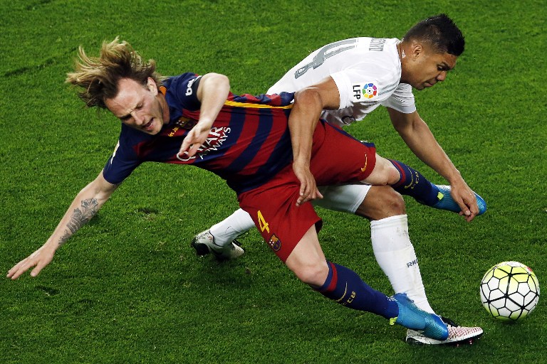 Barcelona's Croatian midfielder Ivan Rakitic (L) vies for a ball with Real Madrid's Brazilian midfielder Casemiro during the Spanish league "Clasico" football match FC Barcelona vs Real Madrid CF at the Camp Nou stadium in Barcelona on April 2, 2016. / AFP / PAU BARRENA