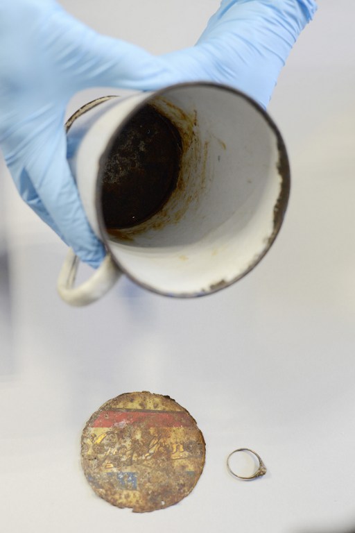 A gold ring that was found by curators of Auschwitz - Birkenau Museum in a metal mug with double bottom is pictured on May 19, 2016 in Oswiecim. More than 70 years after the liberation of the World War II camp in occupied Poland, staff discovered the jewellery in a rusting enamel mug, one of thousands of pieces of kitchenware now on display at the museum. / AFP PHOTO / BARTOSZ SIEDLIK