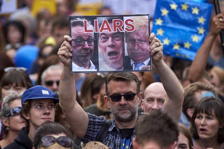 A woman holds up a placard depicting Michael Gove, Nigel Farage and Boris Johnson as liars as thousands of protesters take part in a March for Europe, through the centre of London on July 2, 2016, to protest against Britain's vote to leave the EU, which has plunged the government into political turmoil and left the country deeply polarised. Protesters from a variety of movements march from Park Lane to Parliament Square to show solidarity with those looking to create a more positive, inclusive kinder Britain in Europe. / AFP PHOTO / Niklas HALLE'N