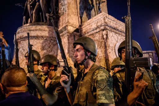 Turkish solders stay at Taksim square as people react in Istanbul on July 16, 2016. Turkish military forces on July 16 opened fire on crowds gathered in Istanbul following a coup attempt, causing casualties, an AFP photographer said. The soldiers opened fire on grounds around the first bridge across the Bosphorus dividing Europe and Asia, said the photographer, who saw wounded people being taken to ambulances. / AFP PHOTO / OZAN KOSE