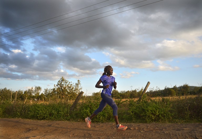 International Olympics Committee (IOC) 2016 olympics refugees team member Rose Nathike Lokonyen runs along a dirt road at a high altitude training camp, at the foot of the Ngong' hills, approximately 35km southeast of Nairobi, on July 25, 2016, in preparation for the 2016 Olympic games . The five from South Sudan who form the 10-member Team Refugee Olympic Athletics (ROA) selected by the International Olympic Committee in June, are hoping their participation at the Olympics would send a strong message to their native nation, South Sudan, after fresh political tensions erupted between the two warring factions led by President Salva Kirr and his former deputy Riek Machar, which left thousands dead and others displaced. / AFP PHOTO / TONY KARUMBA