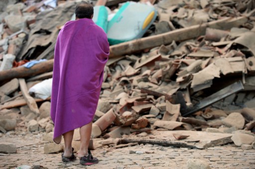 A man stands among the rubble of a house after a strong heartquake hit Amatrice on August 24, 2016. Central Italy was struck by a powerful, 6.2-magnitude earthquake in the early hours, which has killed at least three people and devastated dozens of mountain villages. Numerous buildings had collapsed in communities close to the epicenter of the quake near the town of Norcia in the region of Umbria, witnesses told Italian media, with an increase in the death toll highly likely. / AFP PHOTO / FILIPPO MONTEFORTE