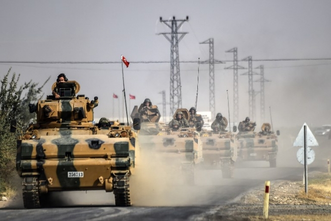 This picture taken around 5 kilometres west from the Turkish Syrian border city of Karkamis in the southern region of Gaziantep, on August 25, 2016 shows Turkish Army tanks driving to the Syrian Turkish border town of Jarabulus. Turkey's army backed by international coalition air strikes launched an operation involving fighter jets and elite ground troops to drive Islamic State jihadists out of a key Syrian border town. The air and ground operation, the most ambitious launched by Turkey in the Syria conflict, is aimed at clearing jihadists from the town of Jarabulus, which lies directly opposite the Turkish town of Karkamis. / AFP PHOTO / BULENT KILIC