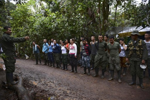 Revolutionary Armed Forces of Colombia (FARC) guerrillas receive instructions at their camp in El Diamante, Caqueta department, Colombia on September 25, 2016. On Monday September 26, 2016 Colombian President Juan Manuel Santos and the leader of the Revolutionary Armed Forces of Colombia (FARC), Rodrigo Londoño - known by his noms de guerre Timoleon Jimenez or Timoshenko - will officially sign a peace agreement in the Cartagena Convention Center to end an armed conflict that has bled the country for over half a century. / AFP PHOTO / RAUL ARBOLEDA