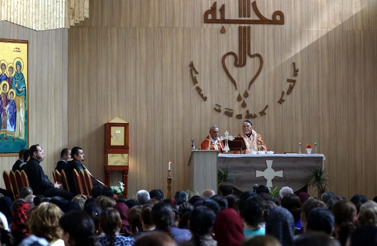 Iraqi Christians, who fled the violence in the northern city of Mosul after Islamic State (IS) group militants took control of the area, attend a mass at the Mar Shmony Church in Arbil, the capital of the autonomous Kurdish region of northern Iraq, on June 5, 2016. / AFP PHOTO / SAFIN HAMED
