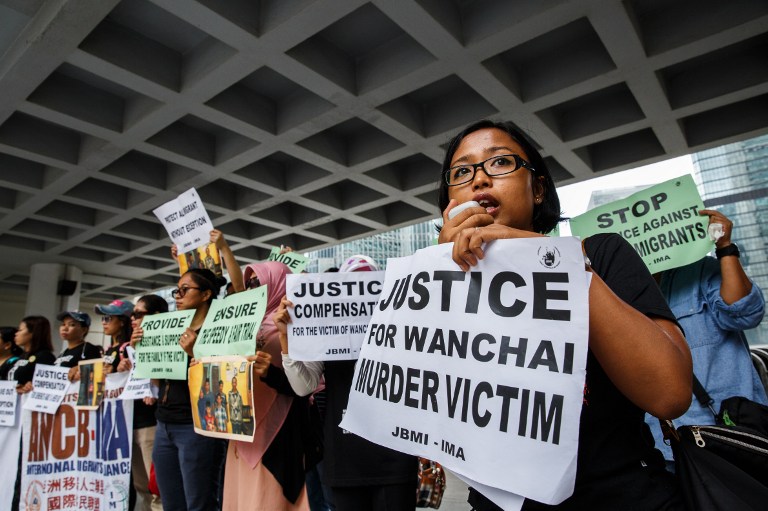 A group of protesters from Indonesian migrant worker organisations hold placards and a photo (C) of victim family members outside the High Court at the beginning of the trial of British banker Rurik Jutting, 31, accused of the murders of two Indonesian women, in Hong Kong on October 24, 2016, on the first day of what is Hong Kong's biggest murder case for years. Jutting pleaded "not guilty" to two charges of murder on October 24 as he stood trial for the killings of two Indonesian women who were found in his upscale Hong Kong apartment. / AFP PHOTO / Anthony WALLACE