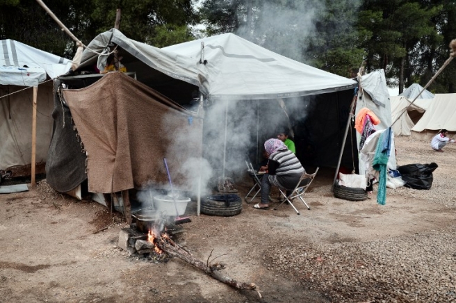 A family prepares dinner at the Ritsona refugee camp, north of Athens, on October 21, 2016. The Ritsona refugee camp hosts some 500 refugees, mostly Syrian and Syrian Kurd families. More than 60000 refuges are stranded in Greece since the closure of the borders. EU leaders called October 21 for greater efforts to apply the "leverage" of trade and development with Africa in order to curb migrant departures to Europe and speed up the return of those who arrive. / AFP PHOTO / LOUISA GOULIAMAKI