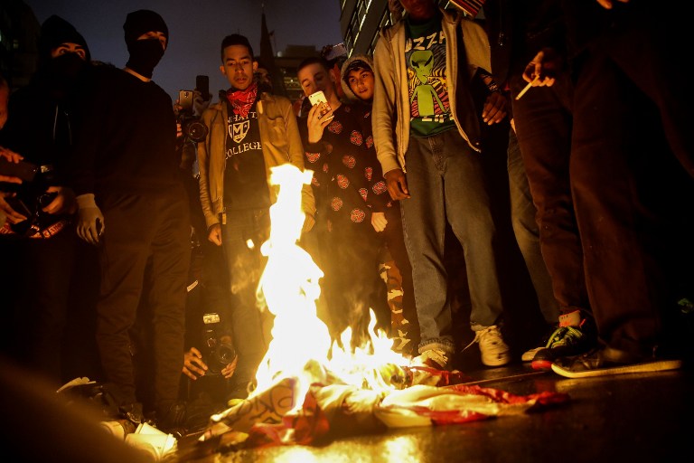 NEW YORK, NY - NOVEMBER 9: Protestors burn an American flag on Fifth Avenue outside of Trump Tower, November 9, 2016 in New York City. Republican candidate Donald Trump won the 2016 presidential election in the early hours of the morning in a widely unforeseen upset. Drew Angerer/Getty Images/AFP